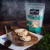 A bag of Vegan Cheeze and Potato Pierogi and some pierogi on a cutting board