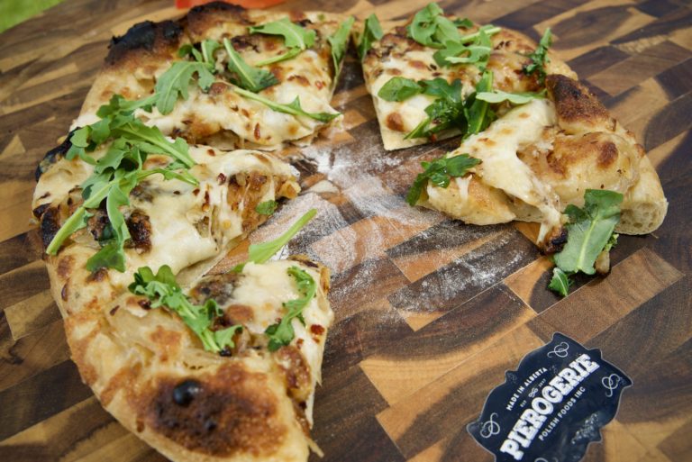 Pierogi pizza, cut into slices on a board
